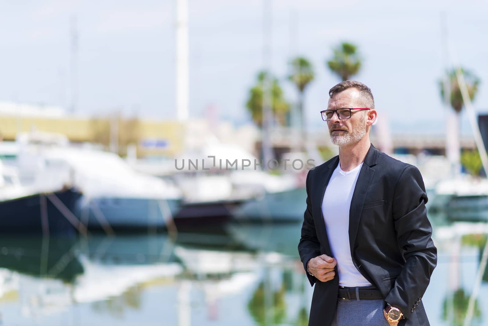 Businessman standing in the city hand on pocket while looking away and smiling