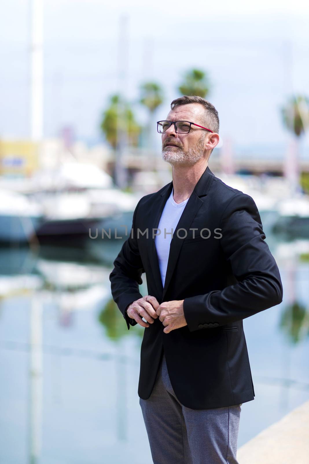 Mature businessman standing in the city looking sideways