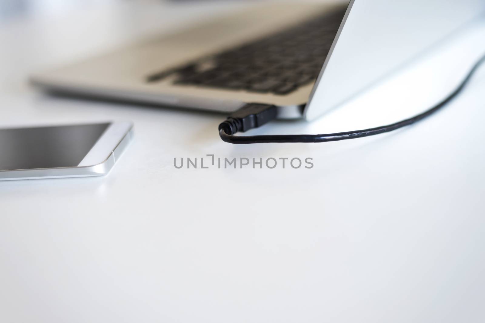 Close up of communicators device on desk, mobile phone and laptop