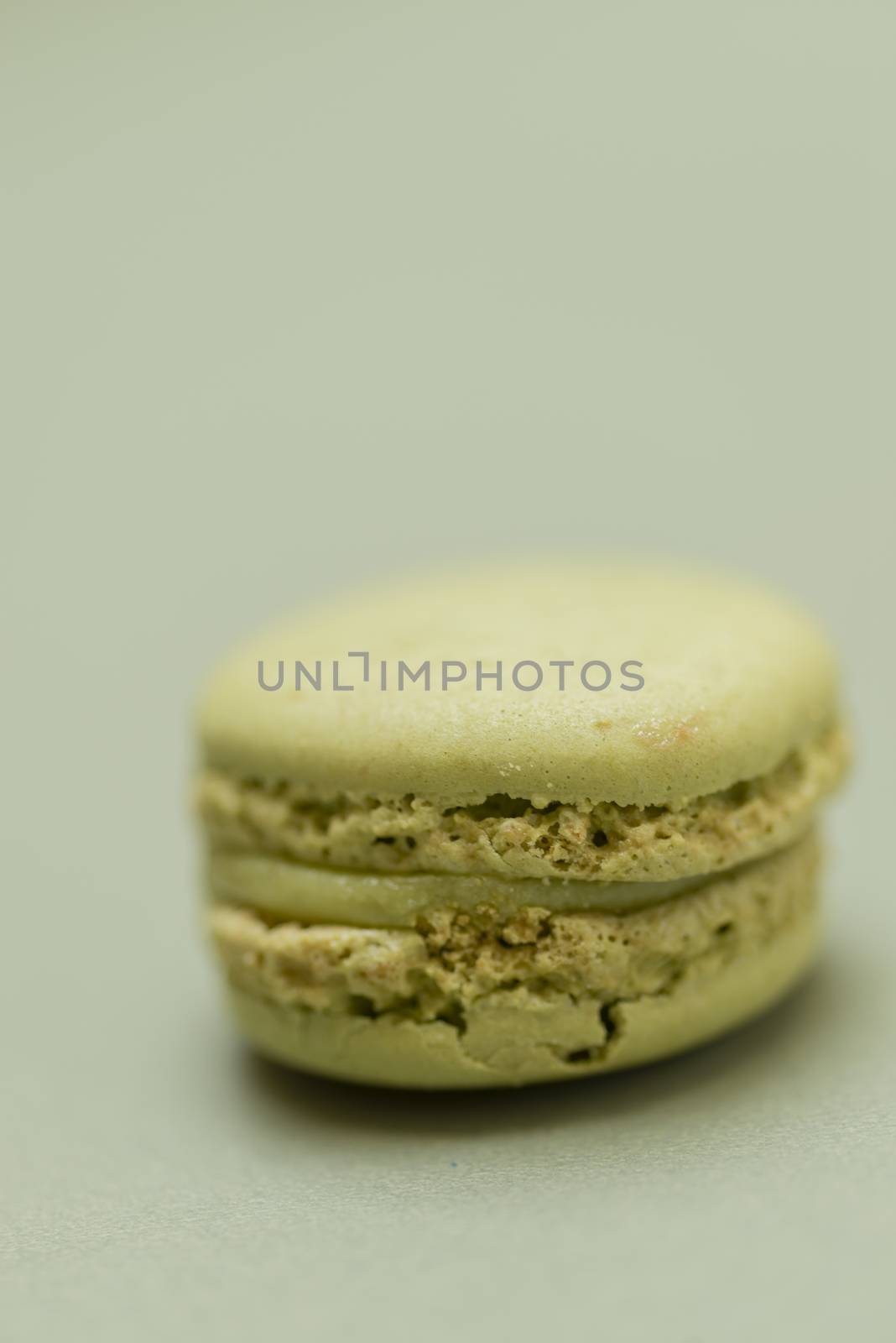 Vintage pastel colored French macaroons or macarons on green background