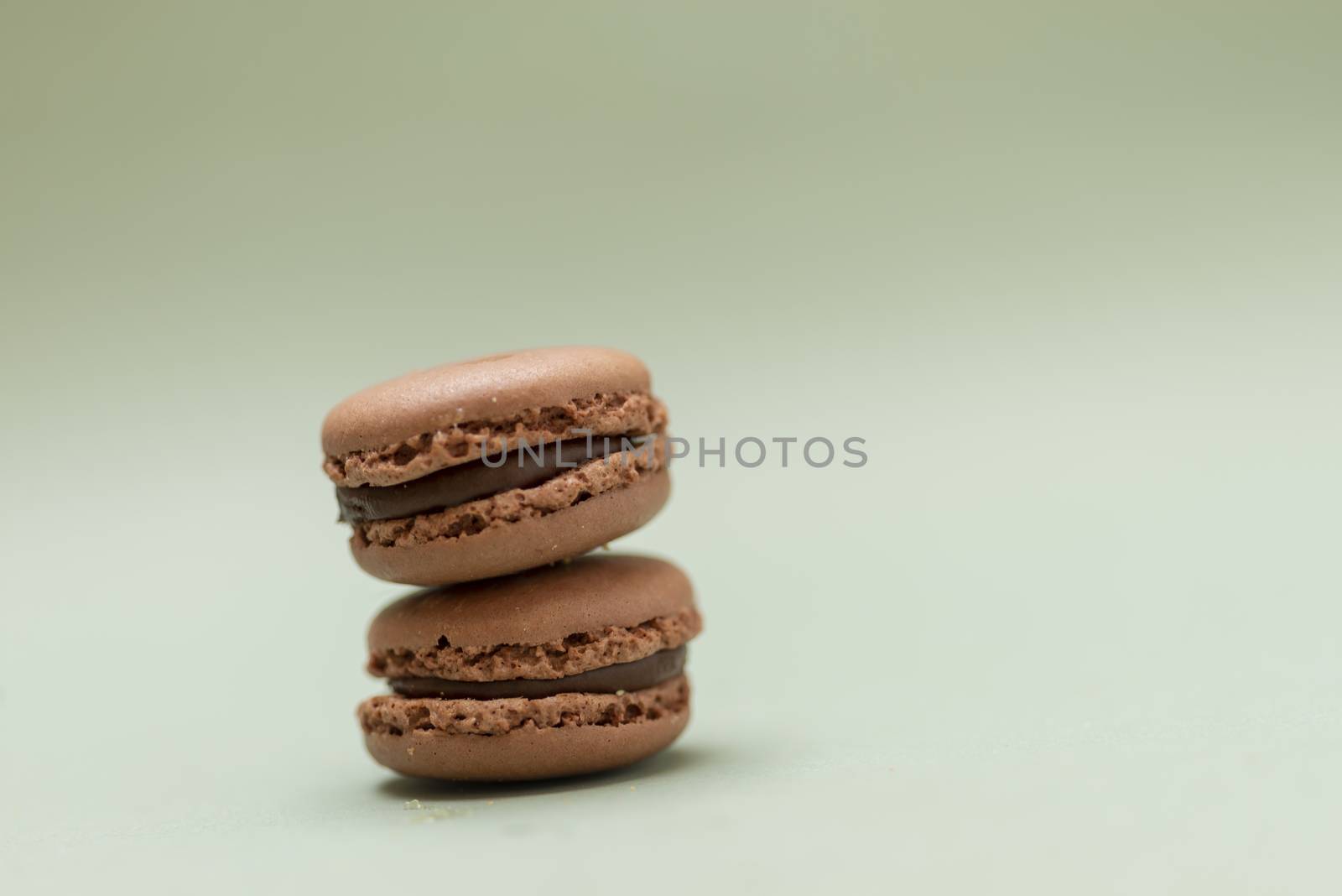 Vintage pastel colored French macaroons or macarons on green background