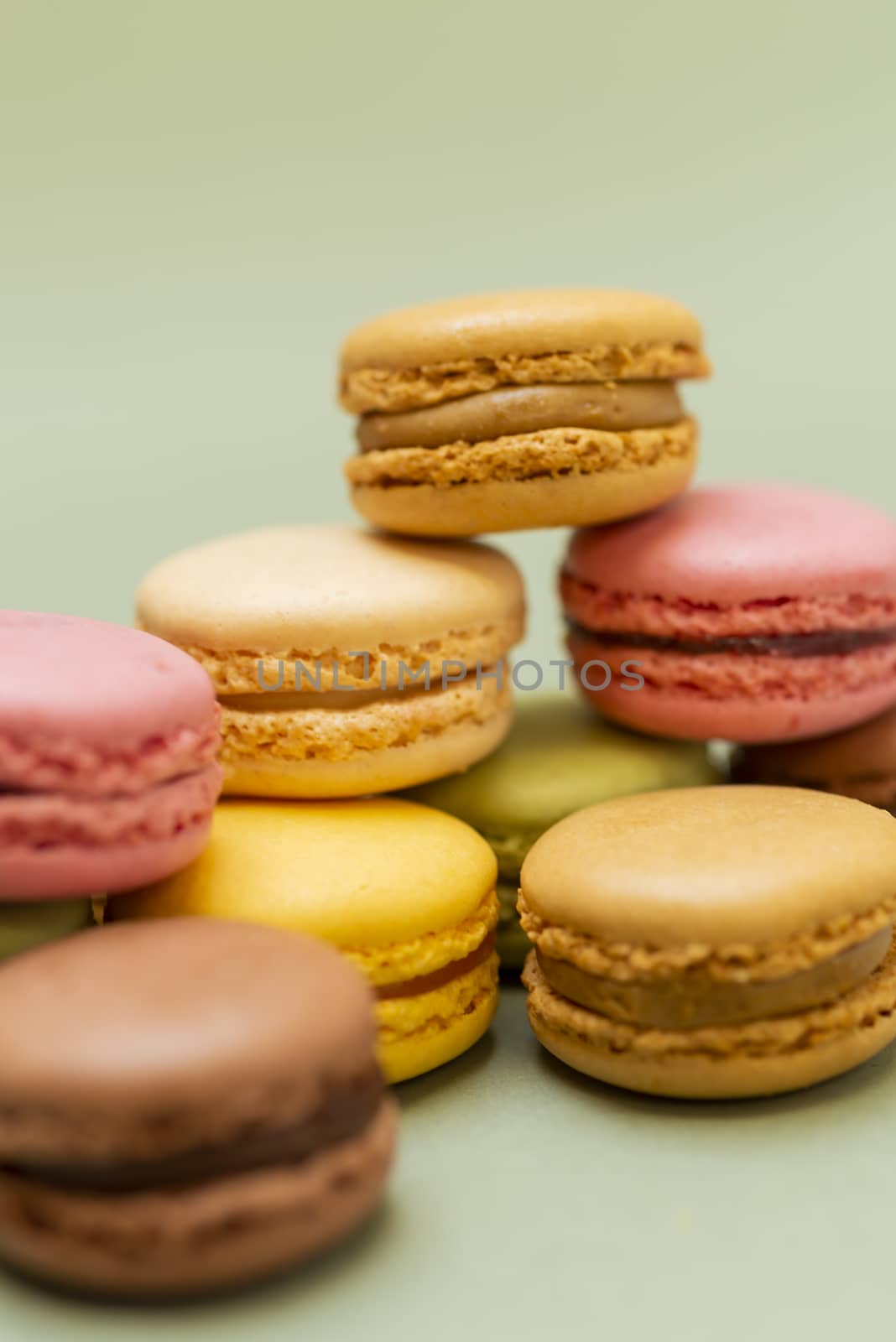 Vintage pastel colored French macaroons or macarons on green background