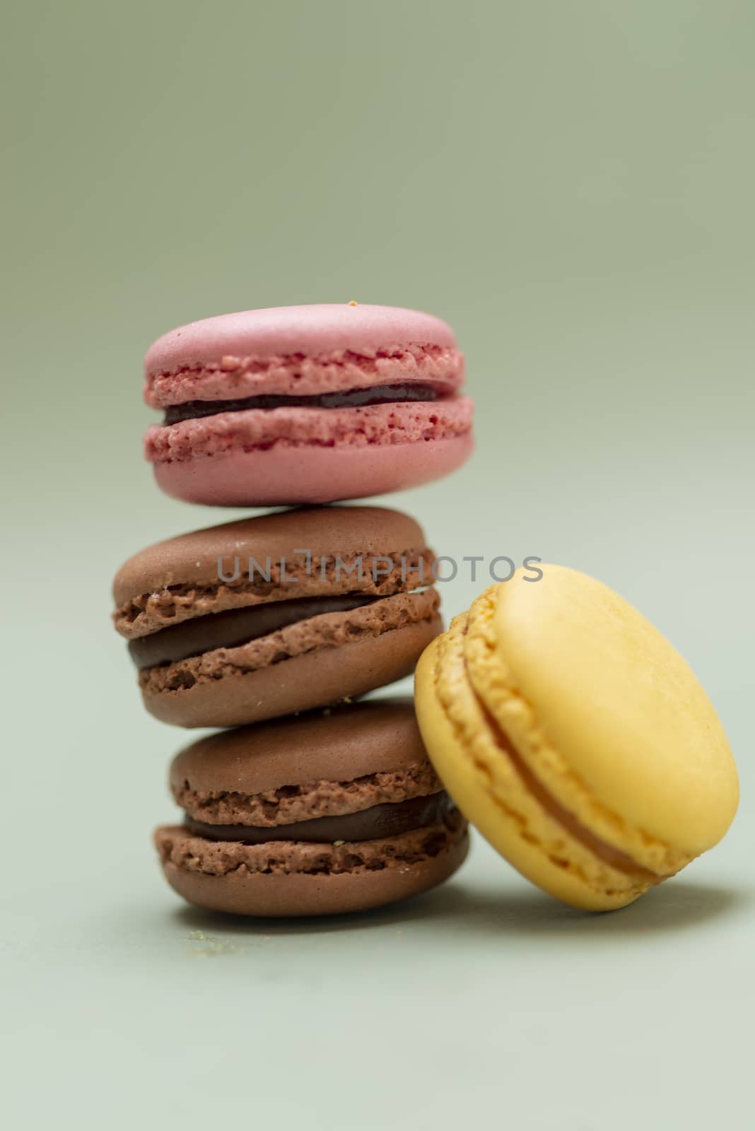 Vintage pastel colored French macaroons or macarons on green background