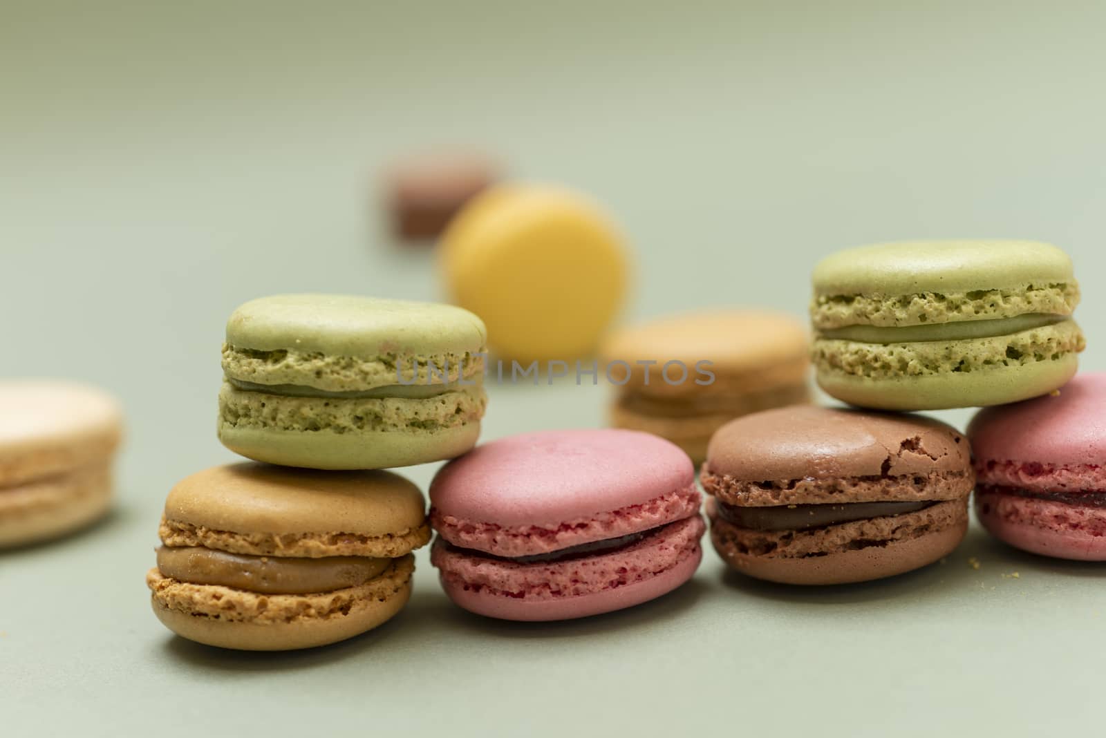 Vintage pastel colored French macaroons or macarons on green background