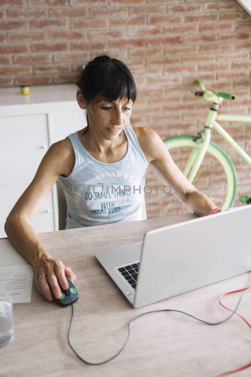 Woman with laptop working at home by raferto1973