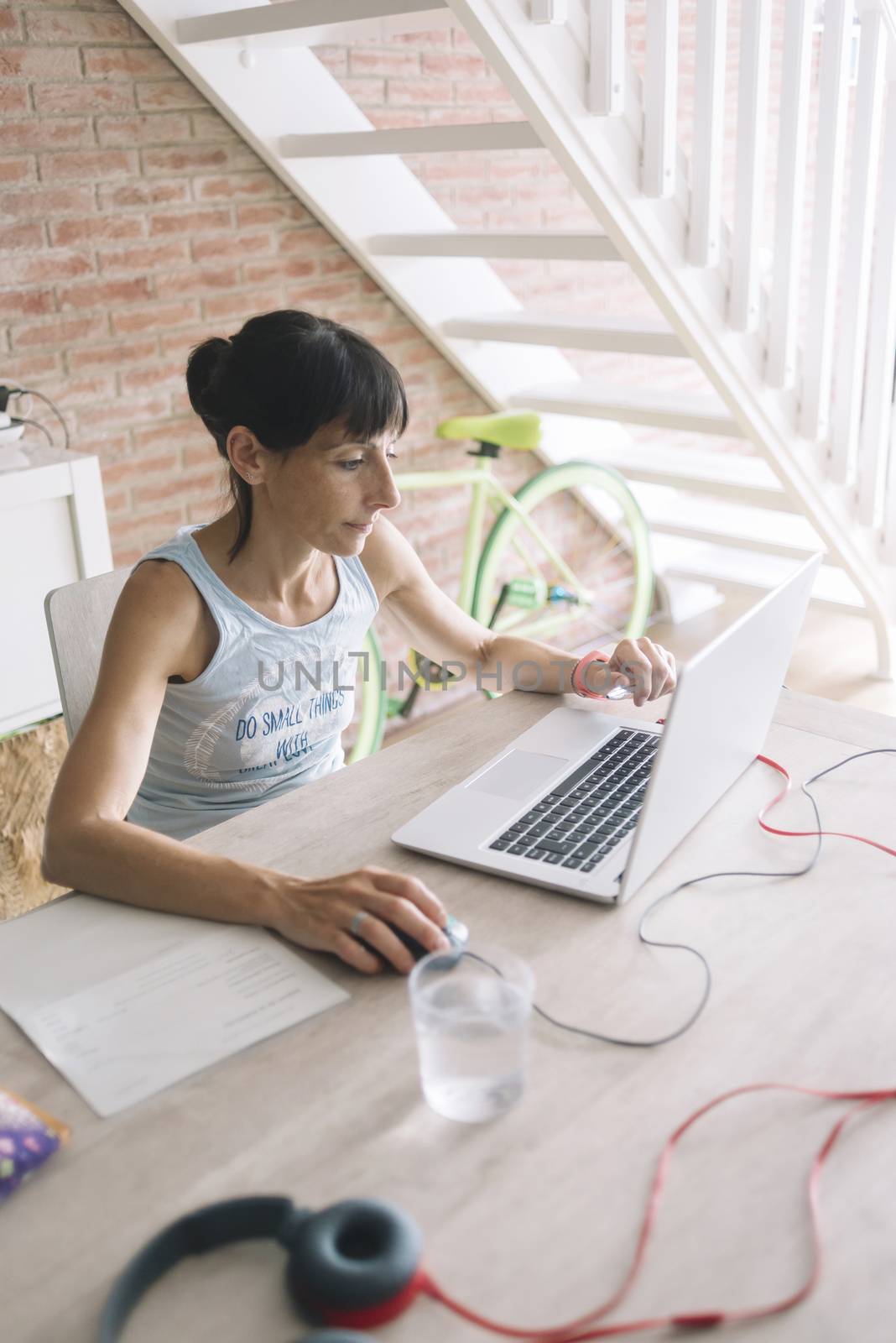 Woman with laptop working at home by raferto1973