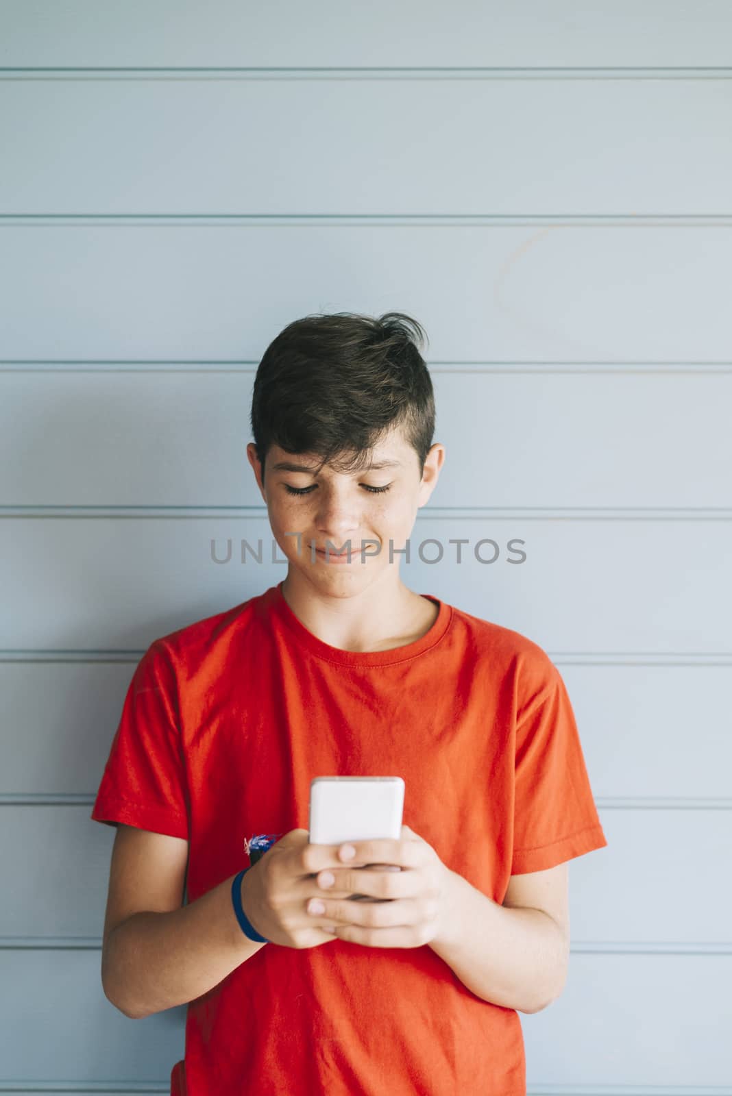 Profile of a happy guy texting on a smart phone