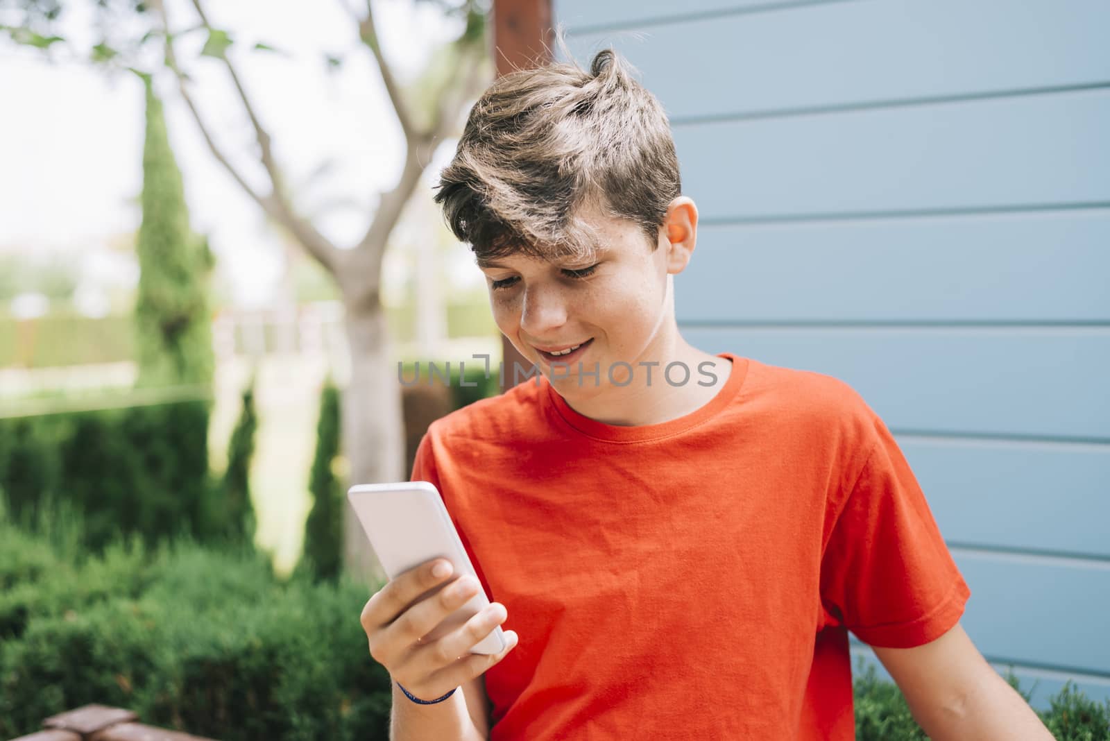 Profile of a happy guy texting on a smart phone