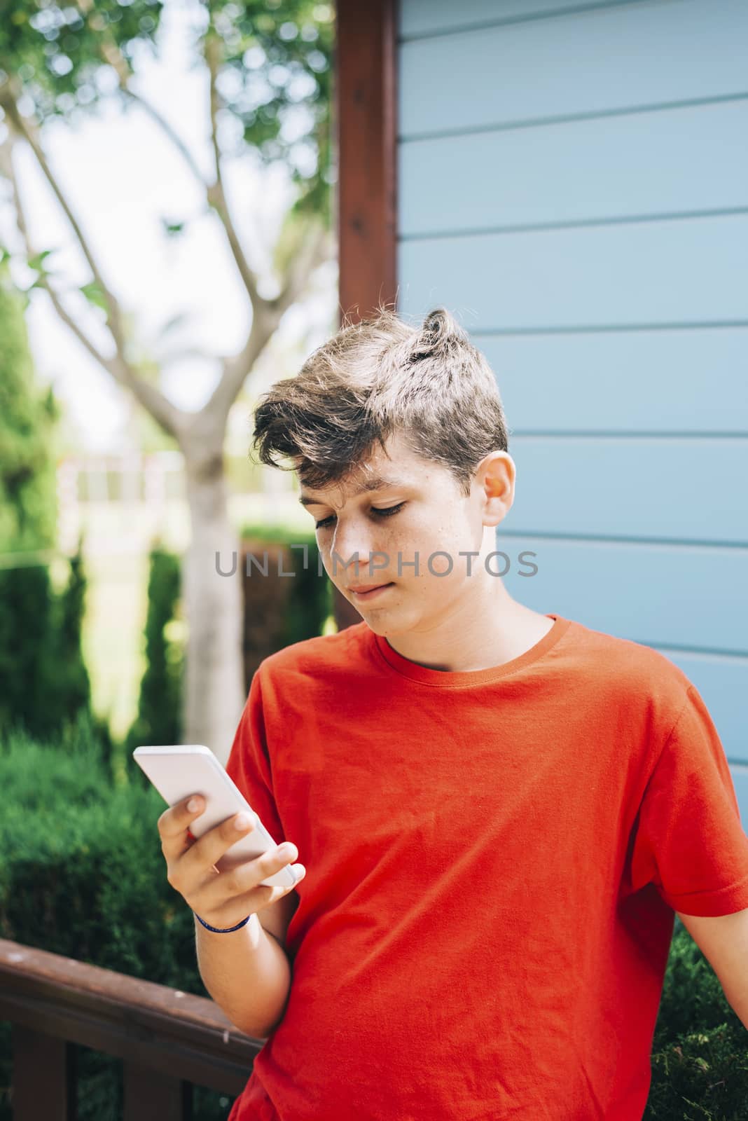 Profile of a happy guy texting on a smart phone