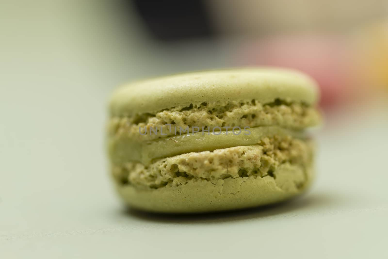 Colored tasty  macaroons over a green background.