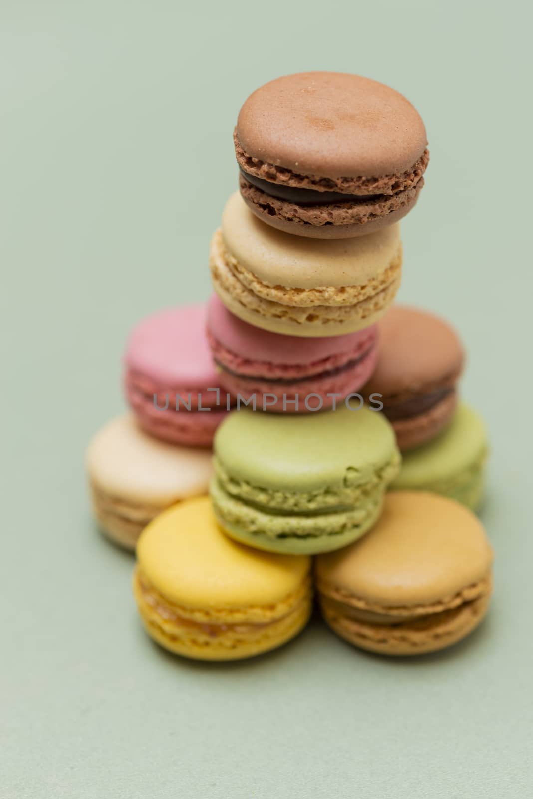 Colored tasty  macaroons over a green background.