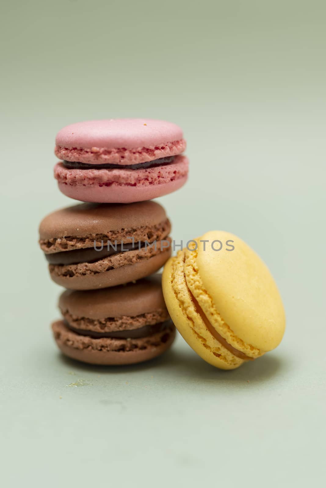 Colored tasty  macaroons over a green background.