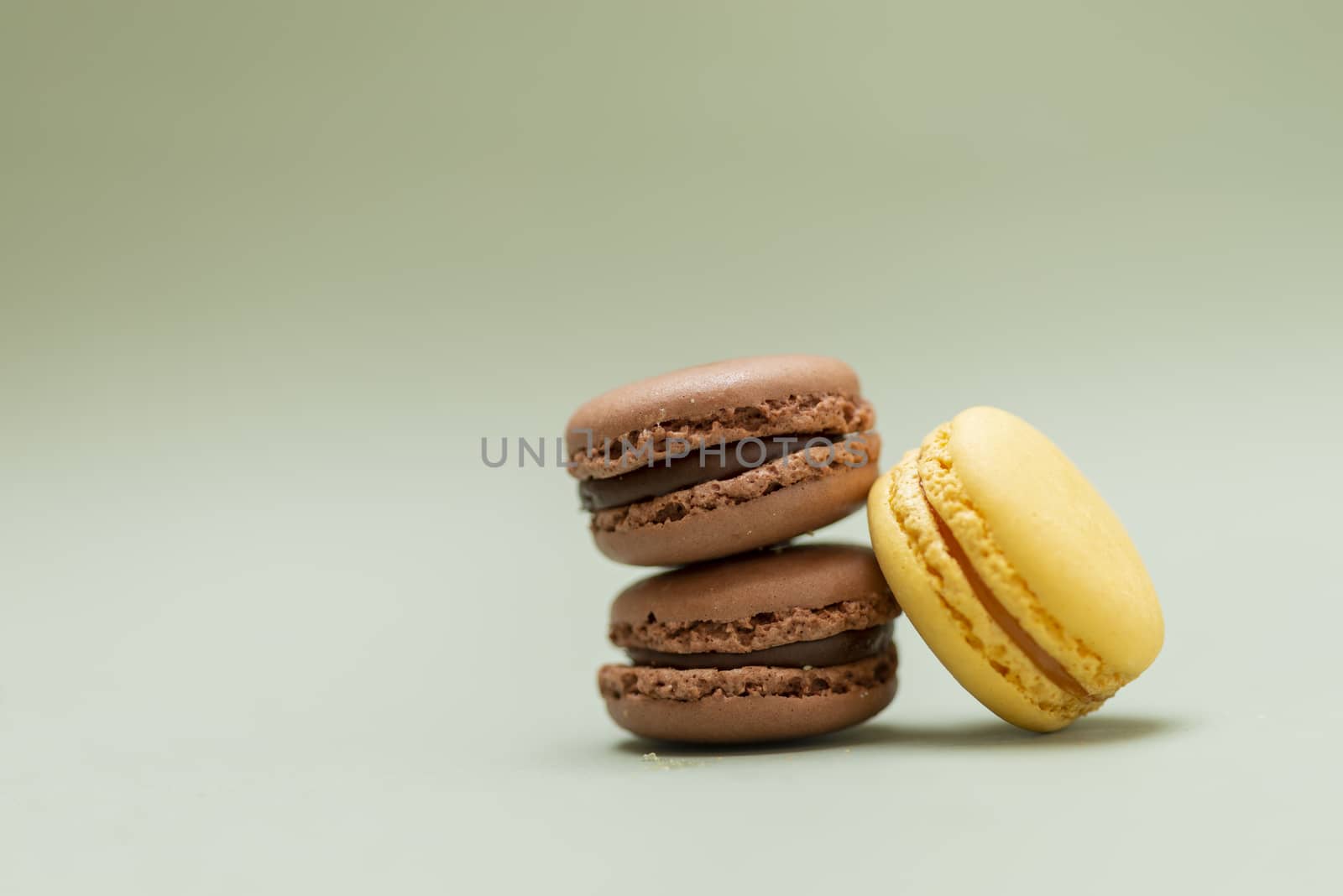 Colored tasty  macaroons over a green background.