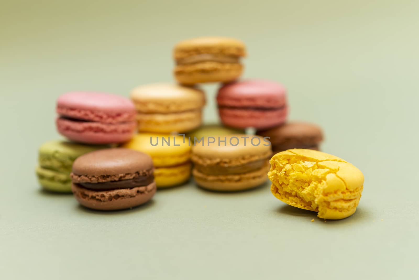 Colored tasty  macaroons over a green background.