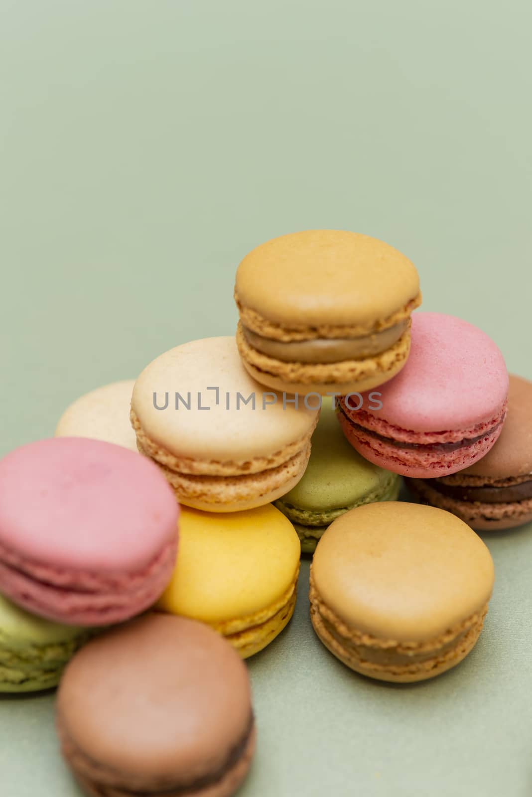 Colored tasty  macaroons over a green background.