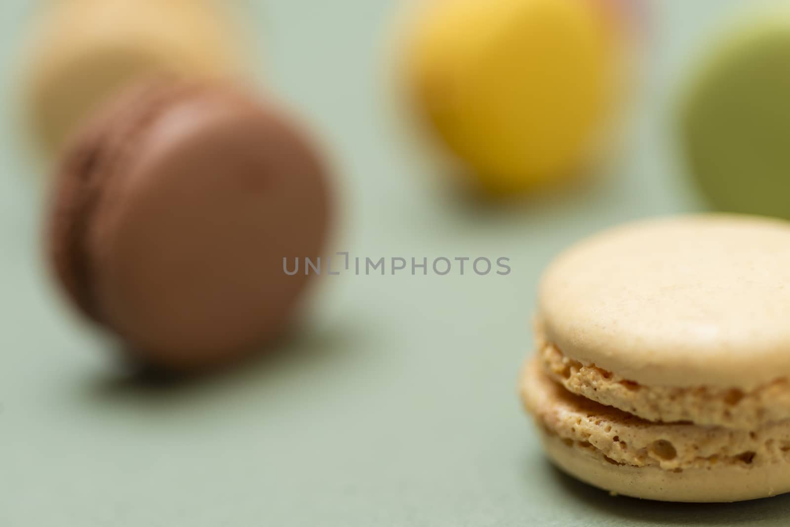 Colored tasty  macaroons over a green background.