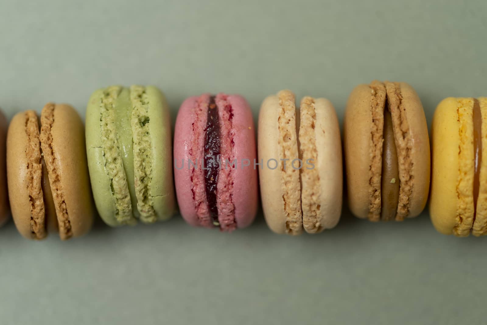 Colored tasty  macaroons over a green background.