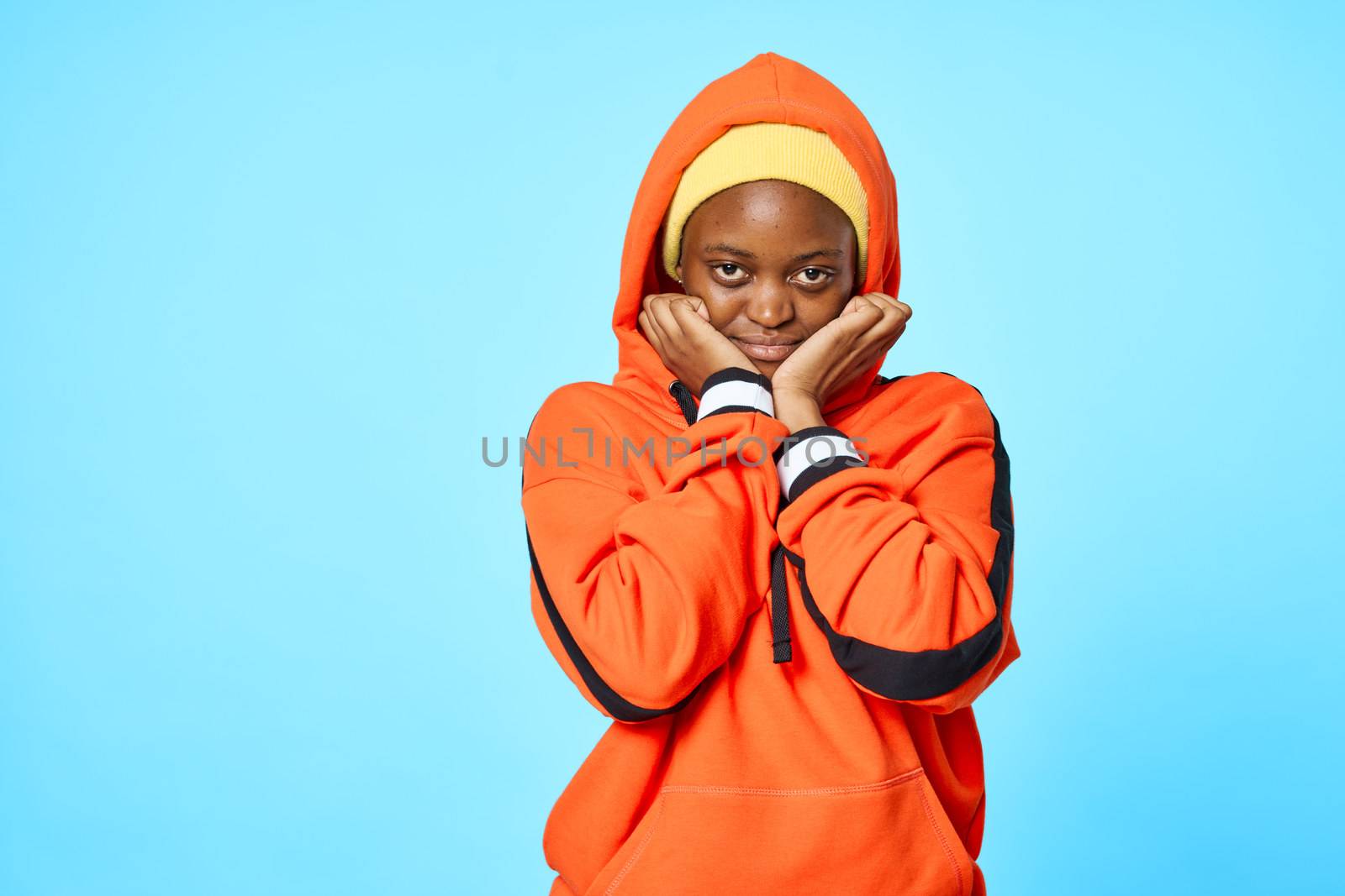Womens fashion clothing studio african appearance lifestyle orange sweater lifestyle blue background