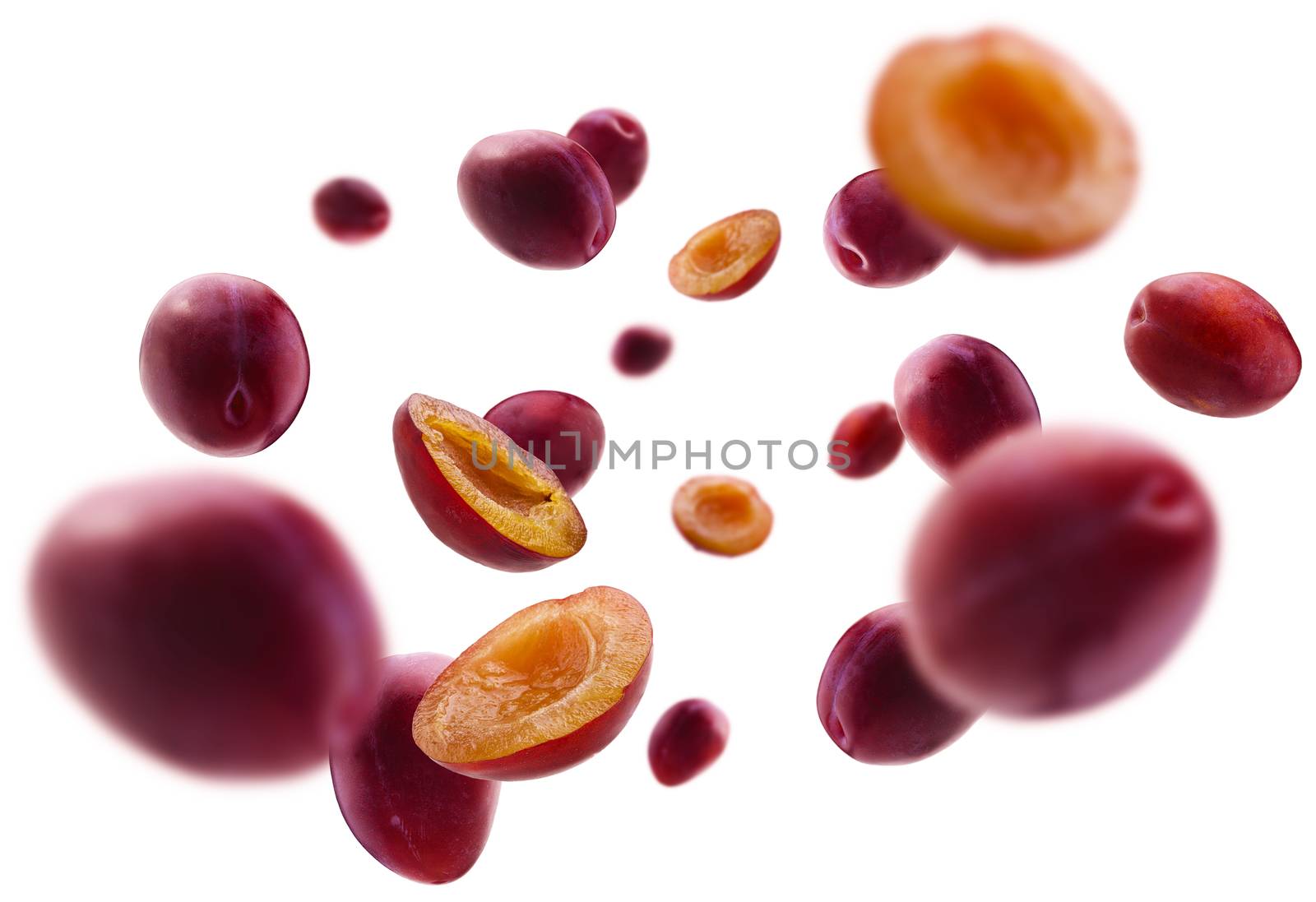 Red plums levitate on a white background.