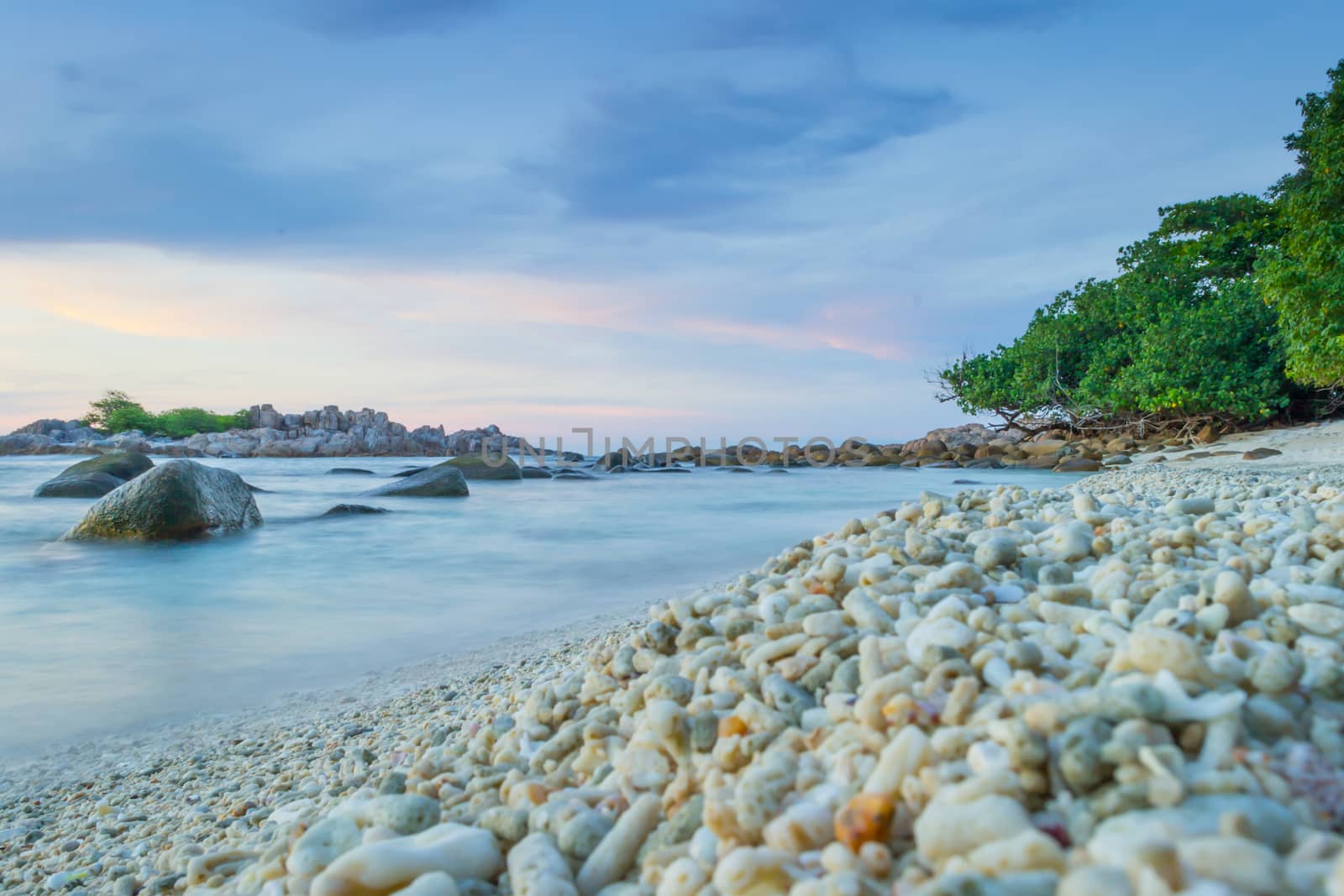 Peaceful and tropical coral turtle beach at Perhentian Islands, Malaysia, long exposure, with cloudy sky during sunset.. Postcard, mural or wallpaper about Malaysian tourism or travel
