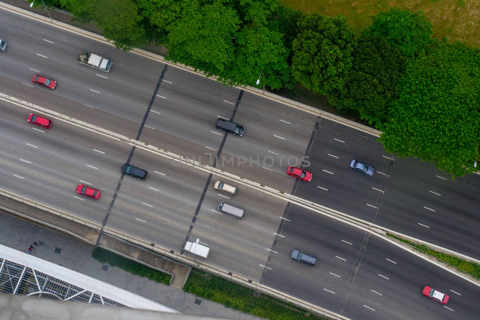 Aerial shot of highway, view from above, with easy traffic, cars and trees on the side by kb79