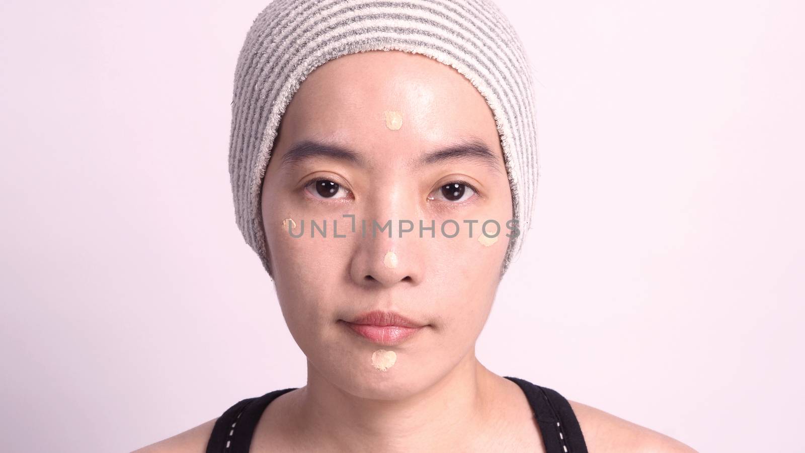 Asian girl making up by foundation liquid real no retouch by gnepphoto