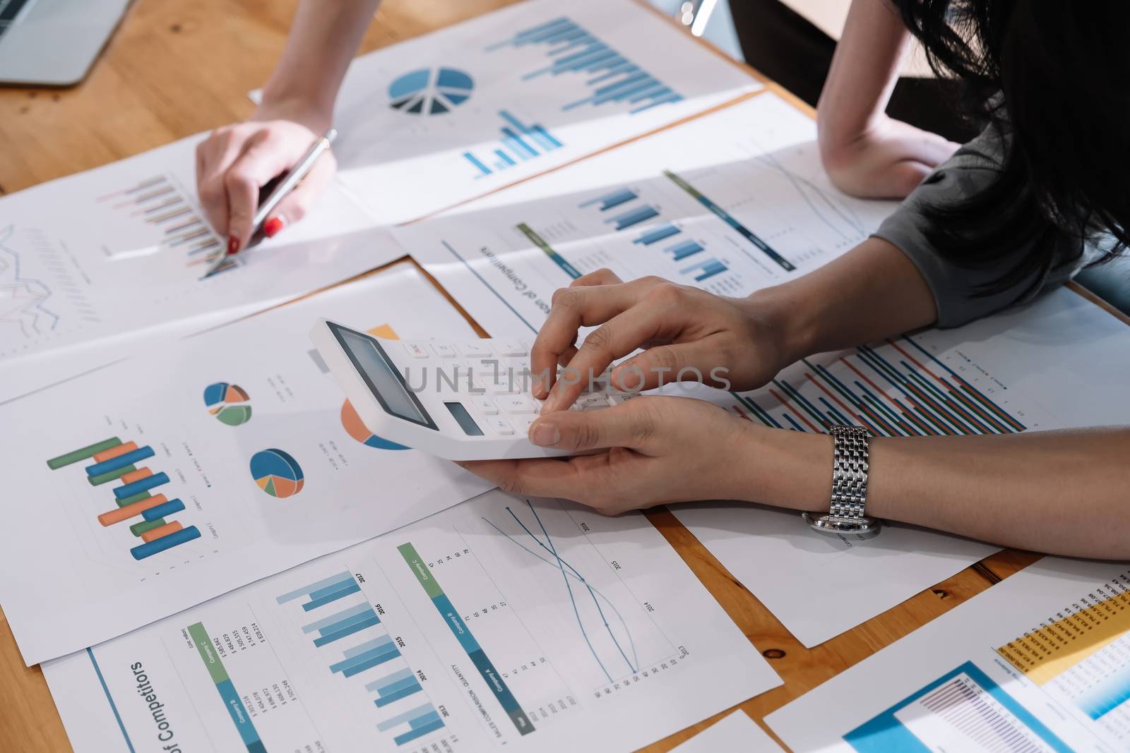 Close up Businessman and partner using calculator and laptop for calaulating finance, tax, accounting, statistics and analytic research concept.