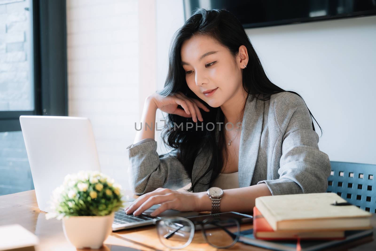 Portrait Young Asian girl working at a her office with a laptop computer.