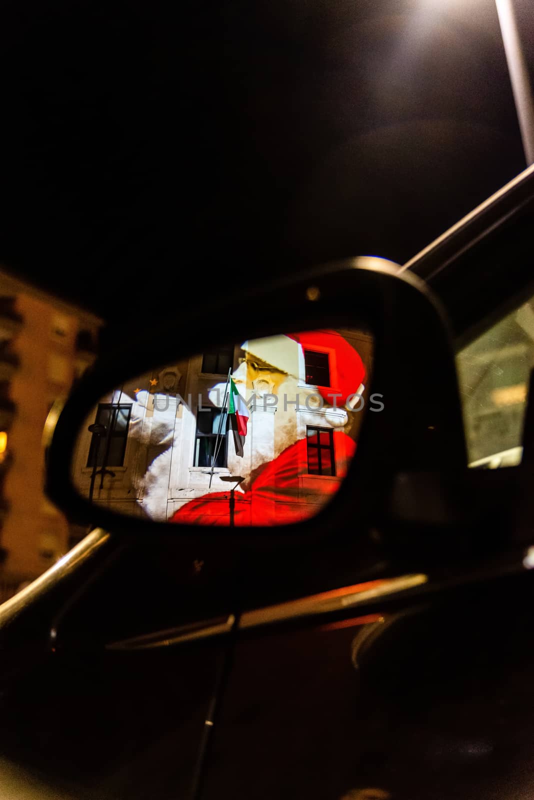 Santa Claus reflected in a car mirror at Christmas time