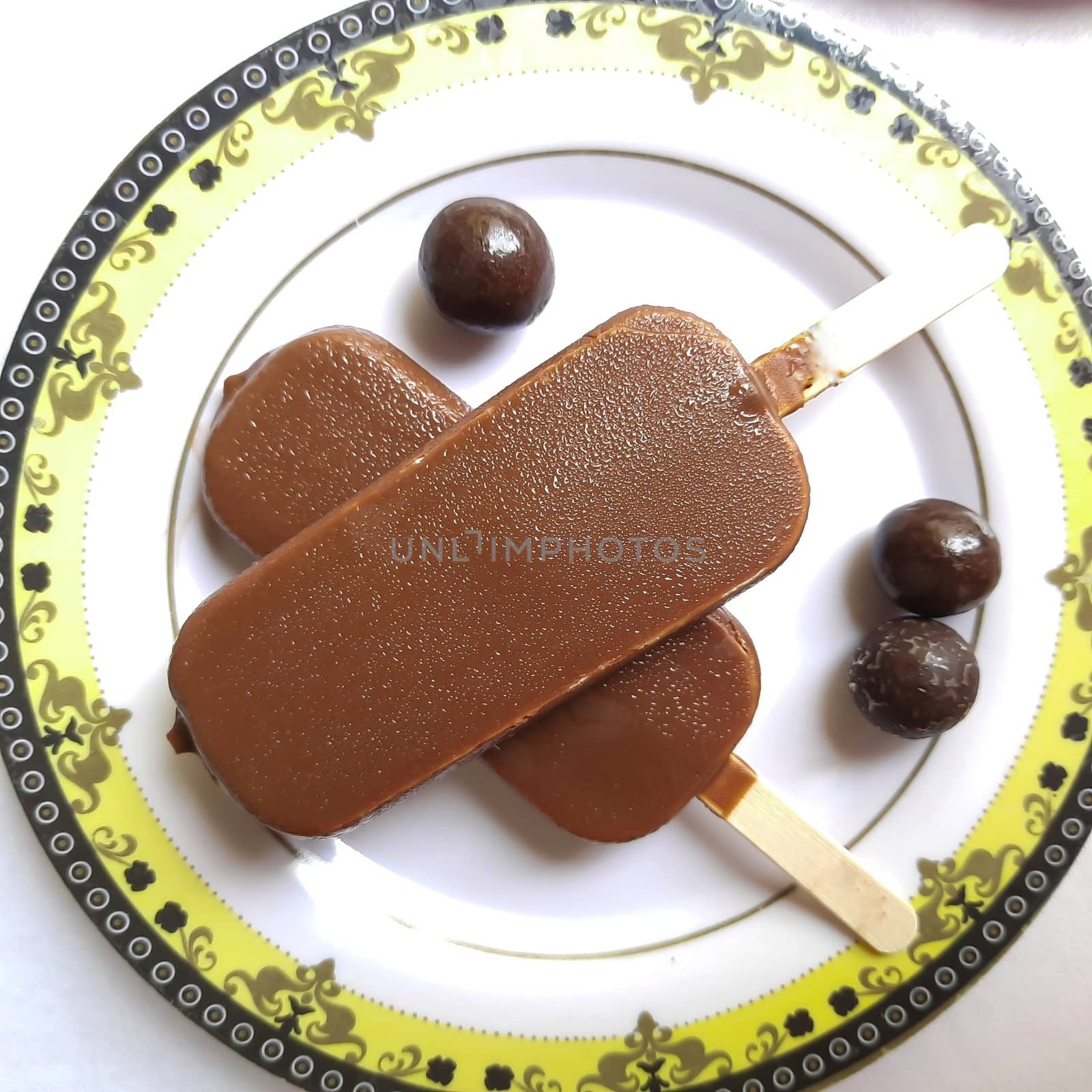 Delicious two chocolate icecream bar with chocolate ball kept beautifully in white plate by AnithaVikram