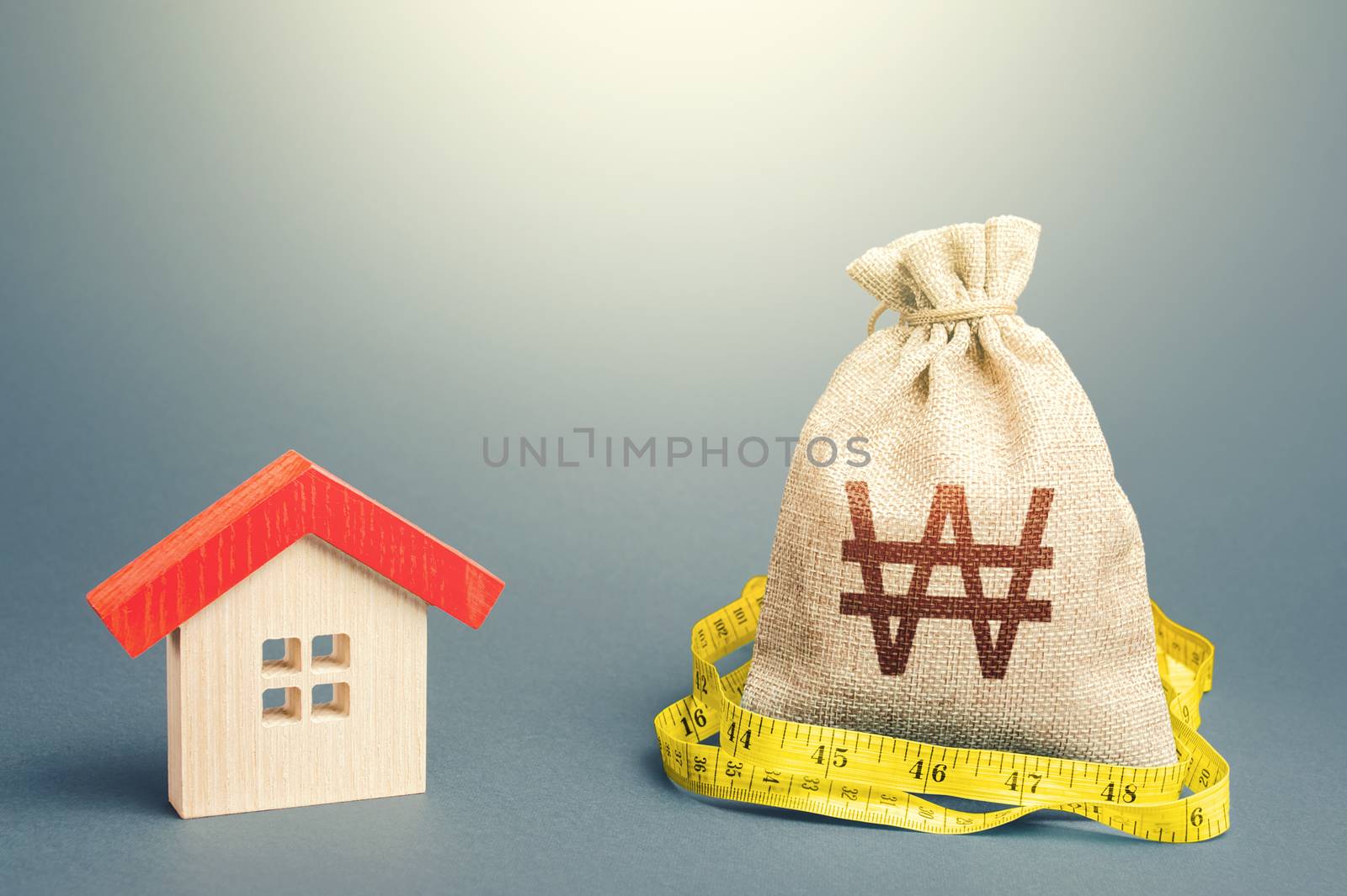 House and south korean won money bag. Mortgage loan. Buying and selling, fair price. Building maintenance. Calculation of expenses for purchase, construction and repair. Property real estate valuation