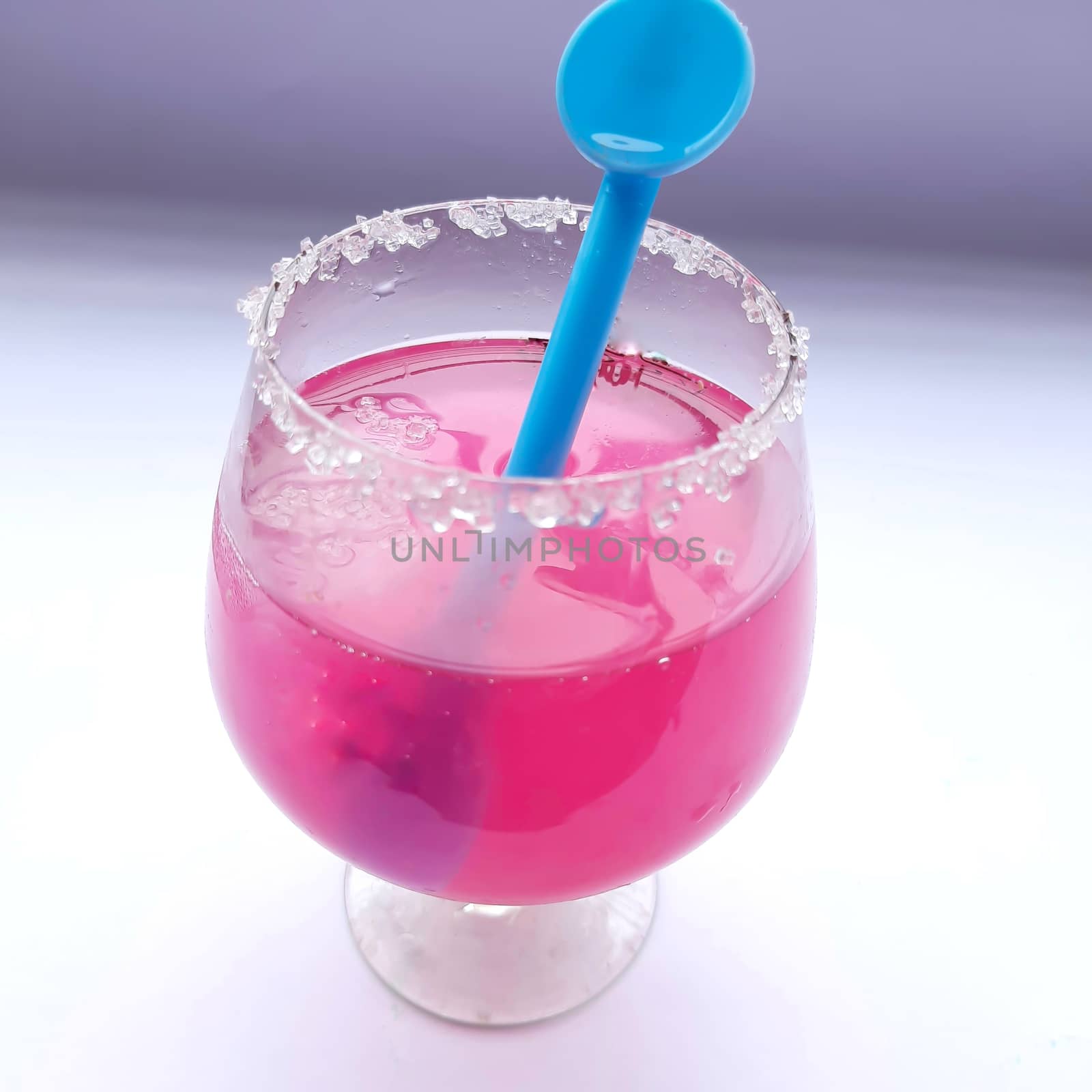 Colorful pink juice added with lemon juice and straw inside it plated beautifully in white background and good for immunity booster