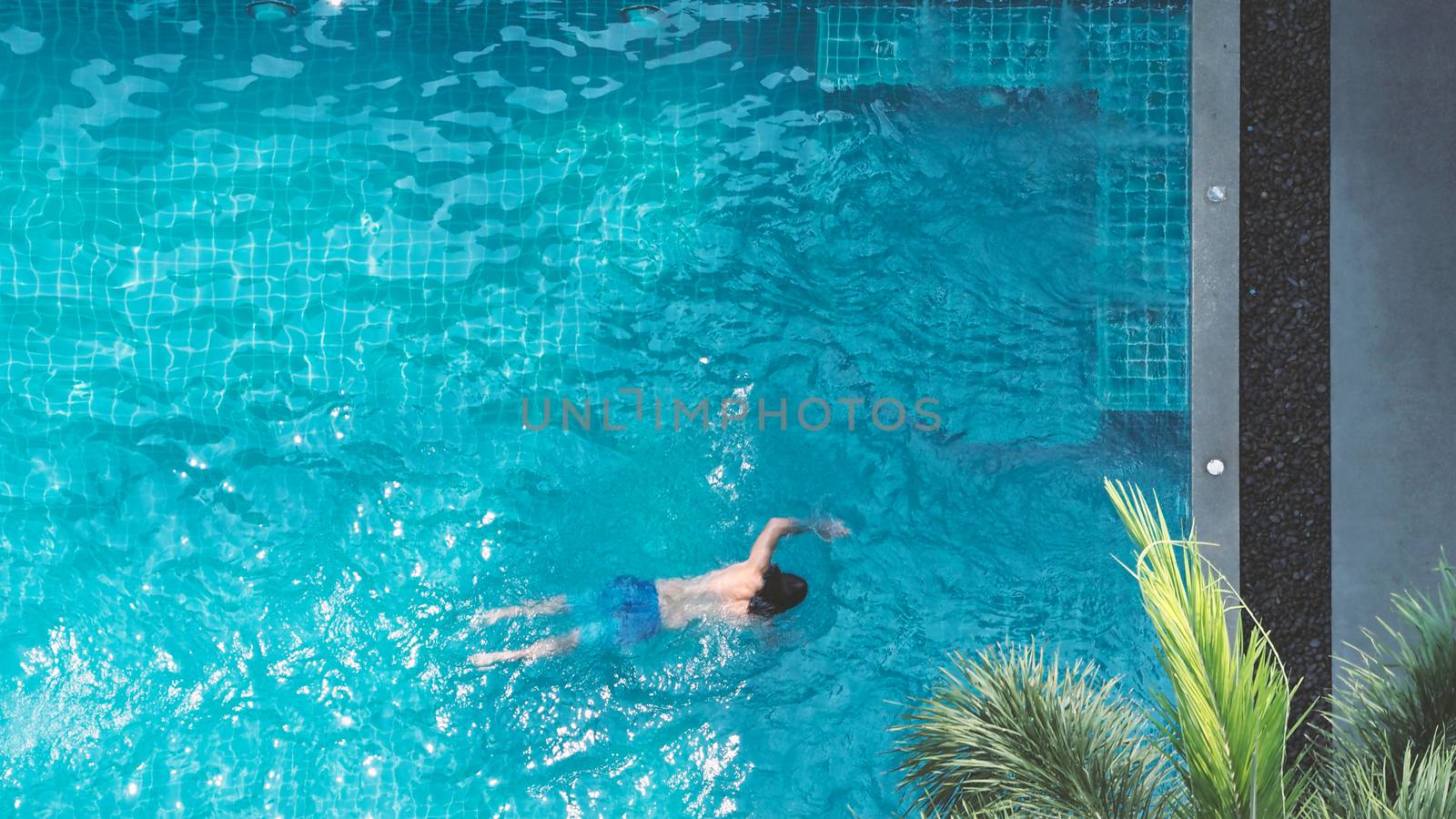 Pool top view angle which young man swimming by gnepphoto