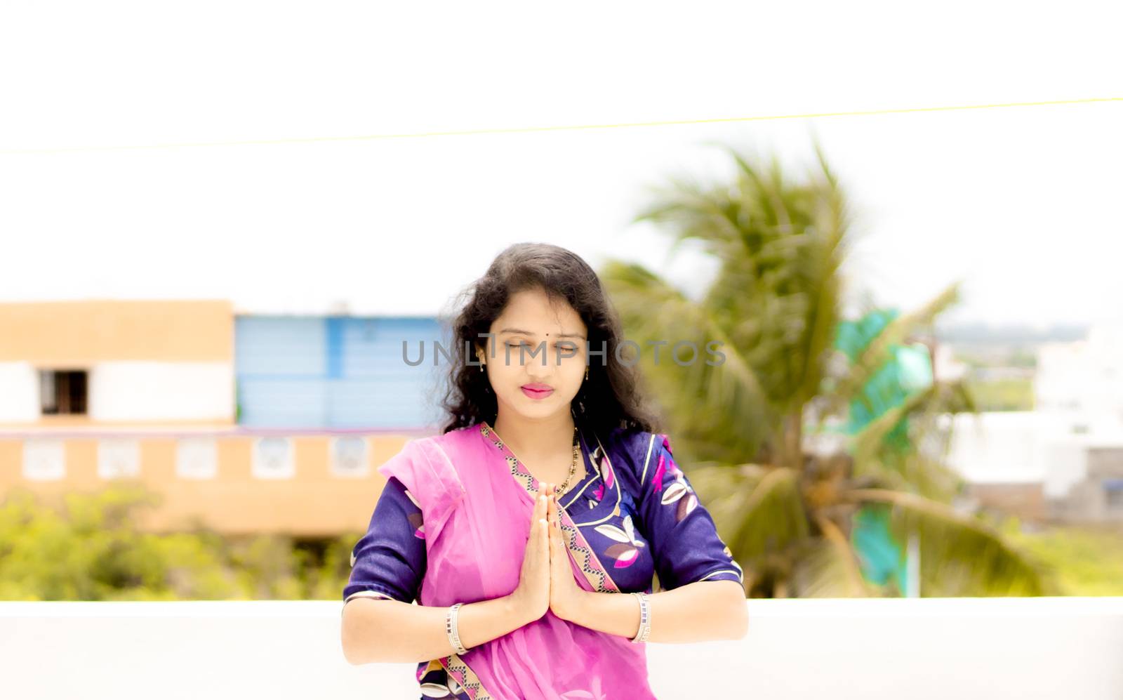 Beautiful Hindu young girl praying with folded hands by 9500102400