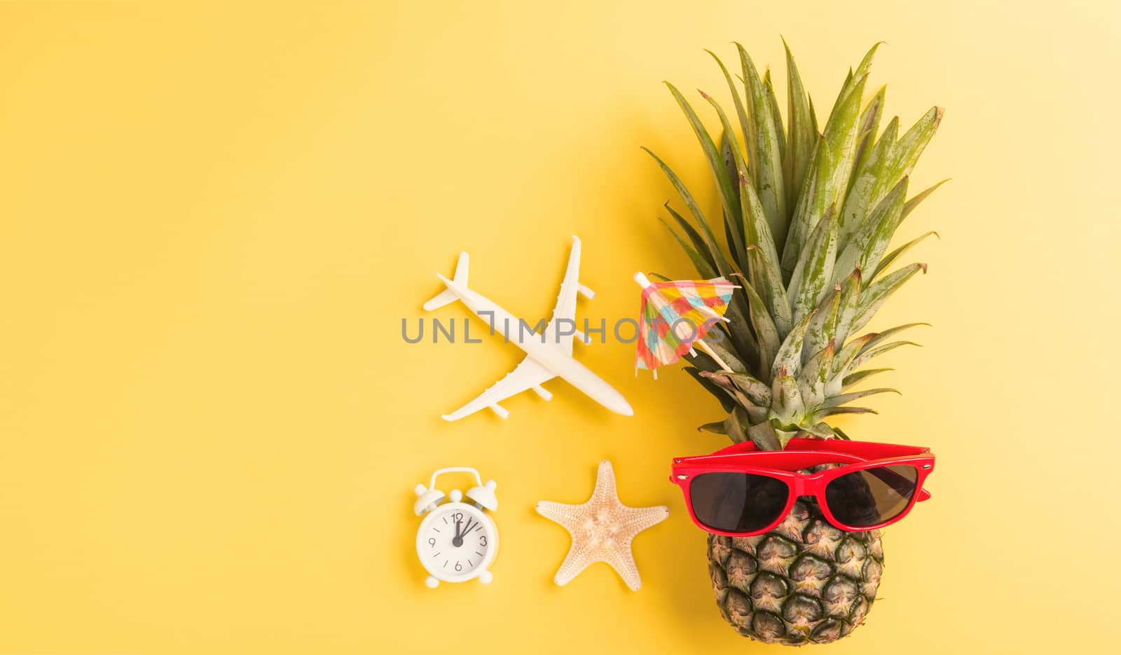 Celebrate Summer Pineapple Day Concept, Top view flat lay of funny fresh pineapple in sunglasses with model plane and starfish, in studio isolated on yellow background, Holiday summertime in tropical