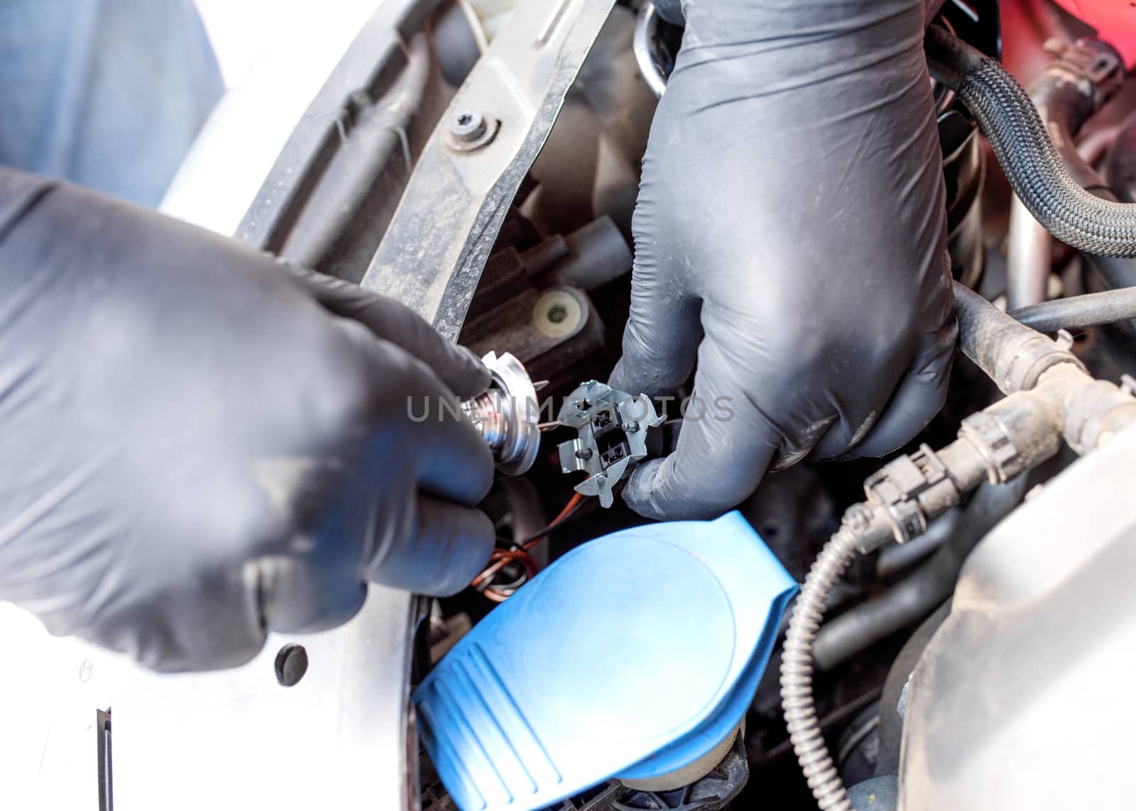 Hand of Man wearing black gloves repairing a car