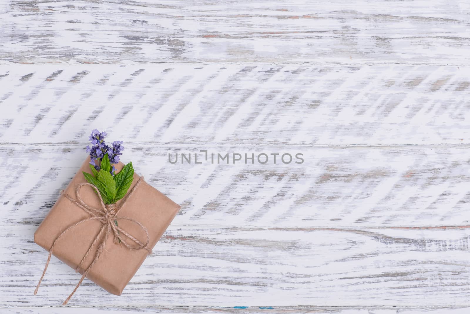 Gift box and posy of lavender on wooden background
