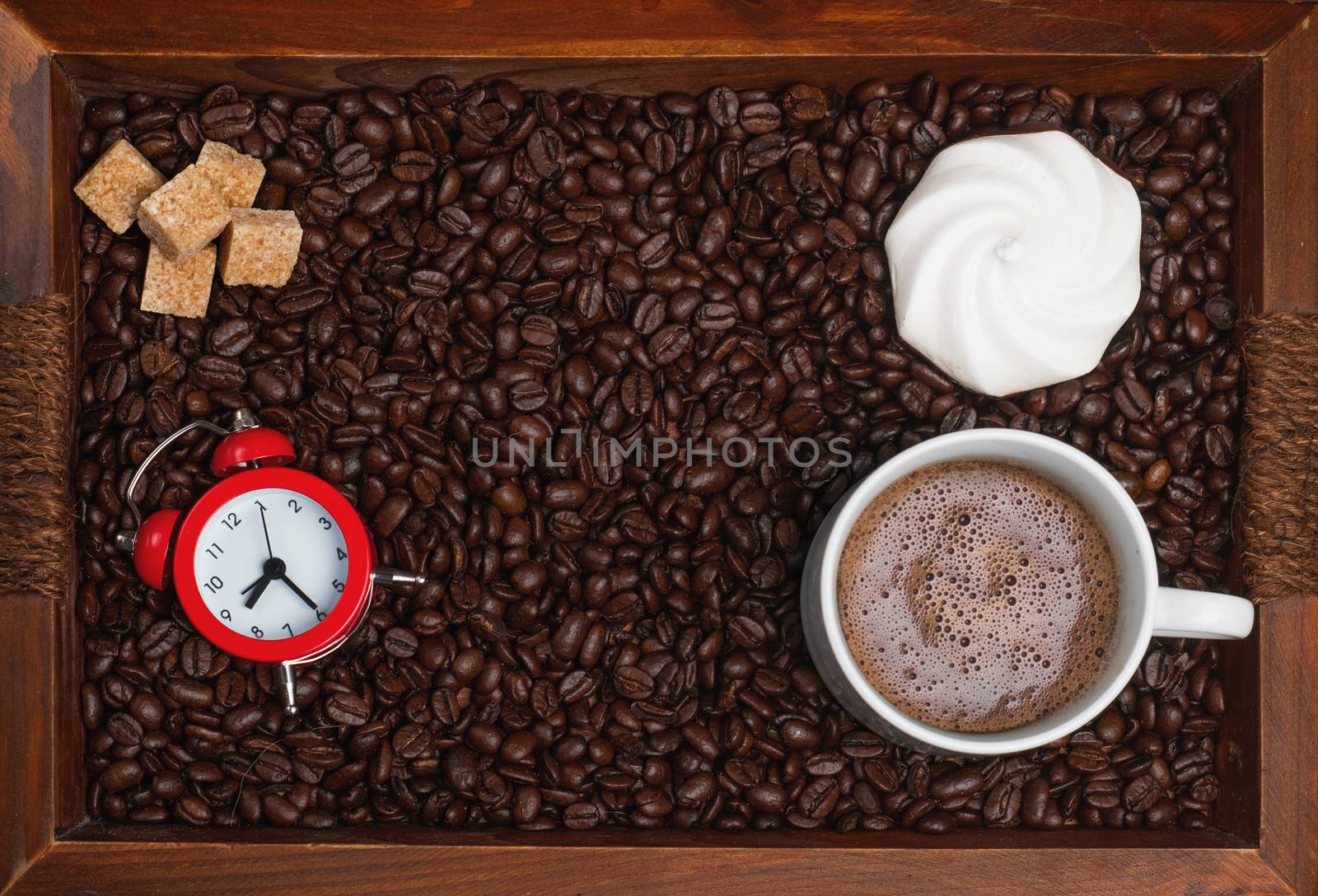 Cup of coffee, biscuit, sugar, watch, coffee beans on a wooden tray. View from the top.