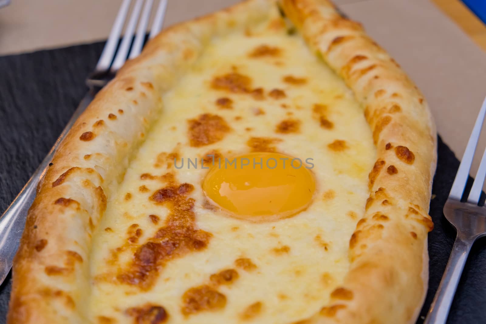 Georgian dish khachapuri with egg in the center. Soft focus. Closeup.