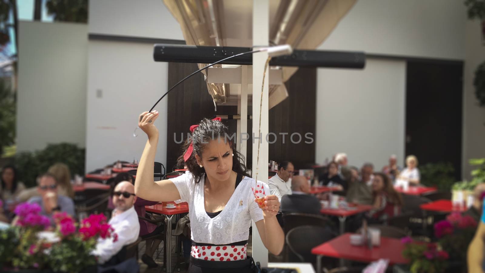 Malaga, Spain, April 2016: waitress serving and pouring Sherry, a traditional habit called Venenciar in Malaga, Spain