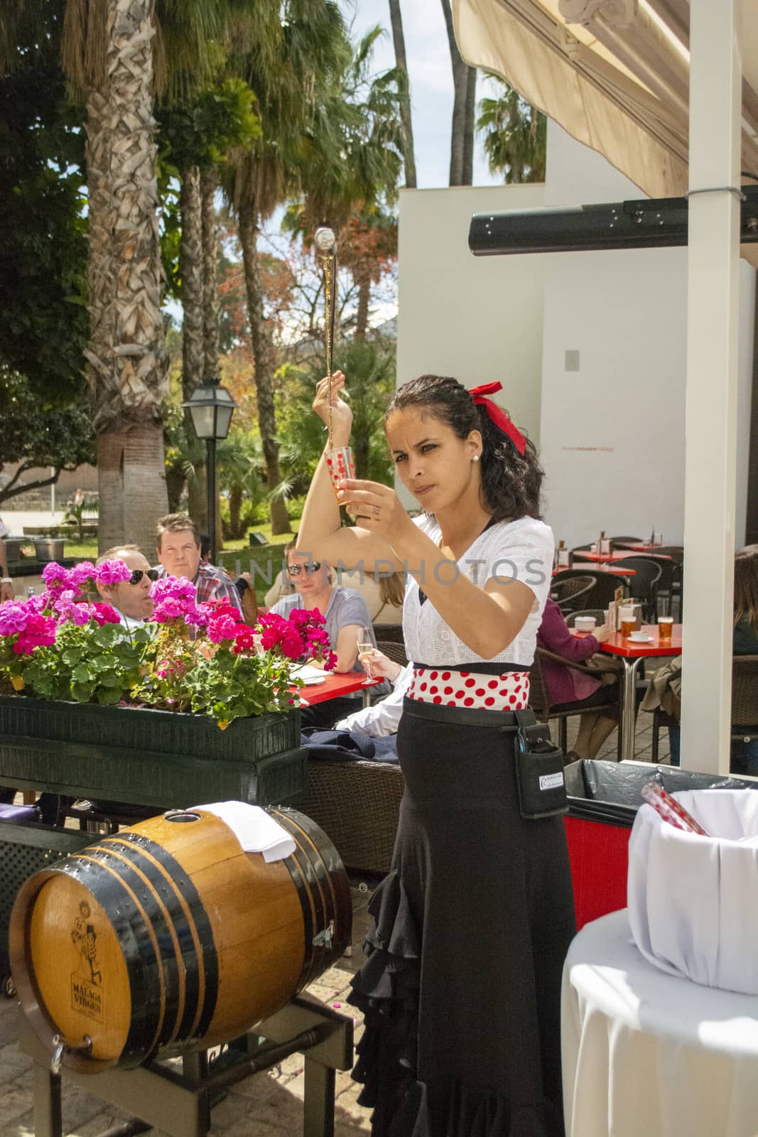 Malaga, Spain, April 2016: waitress serving and pouring Sherry, a traditional habit called Venenciar in Malaga, Spain