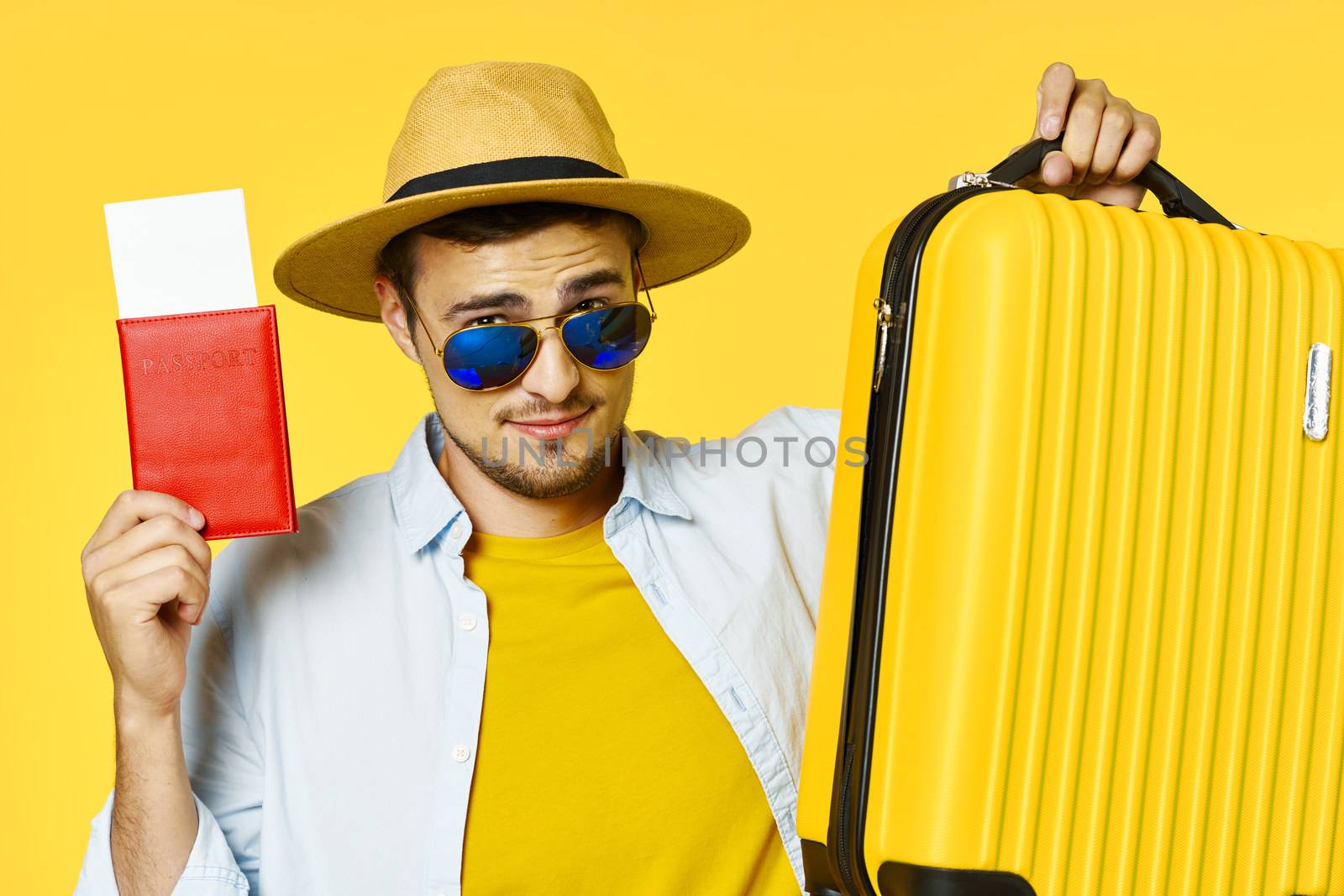 A man with a yellow suitcase and red passport glasses on his face
