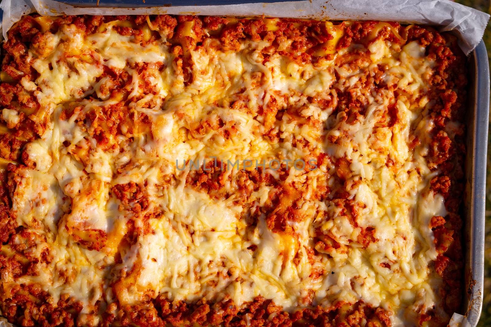 Close up and top view of a freshly baked homemade lasagna ready for serving.