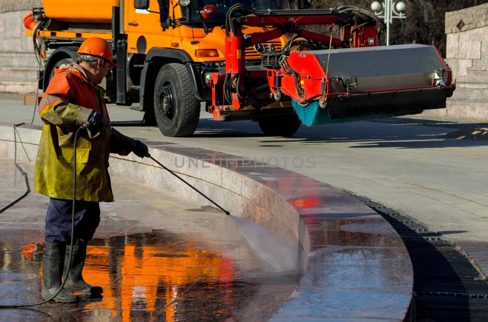 The employee of the municipal services wash the fountain after the winter.