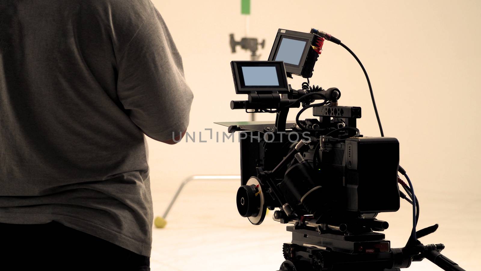 Behind video camera that recording online commercial or web film movie in the big studio production with professional equipment such as high resolution cam and monitors and LED light with crew team set