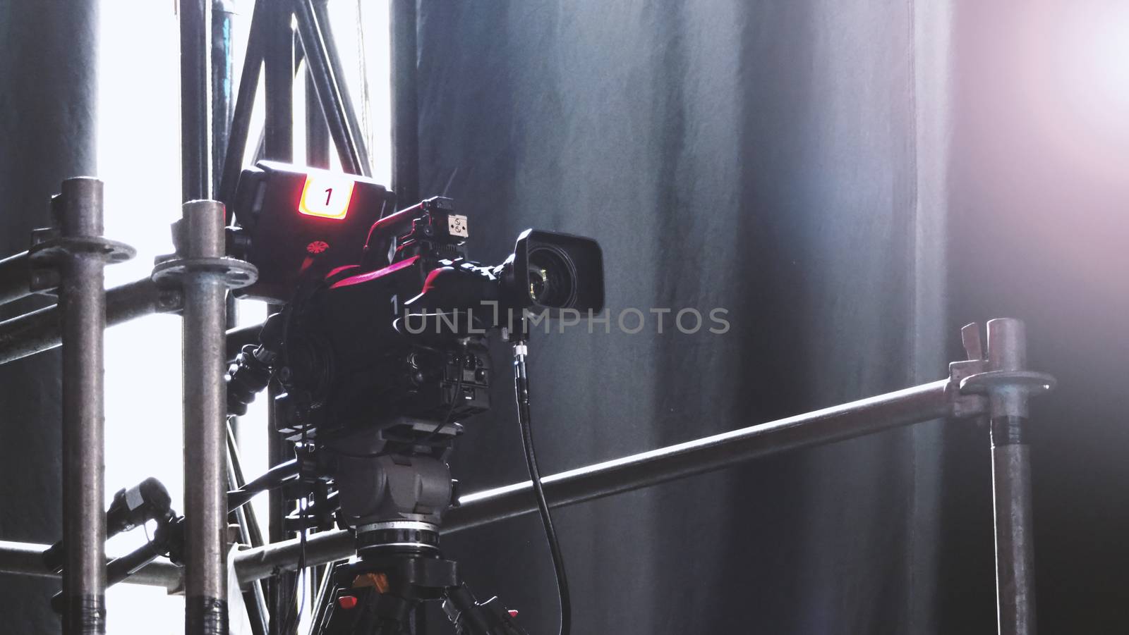 Blurry images of broadcast camera on the crane tripod for easy to shooting or recording and broadcasting content in studio production to on air tv or online internet live show.