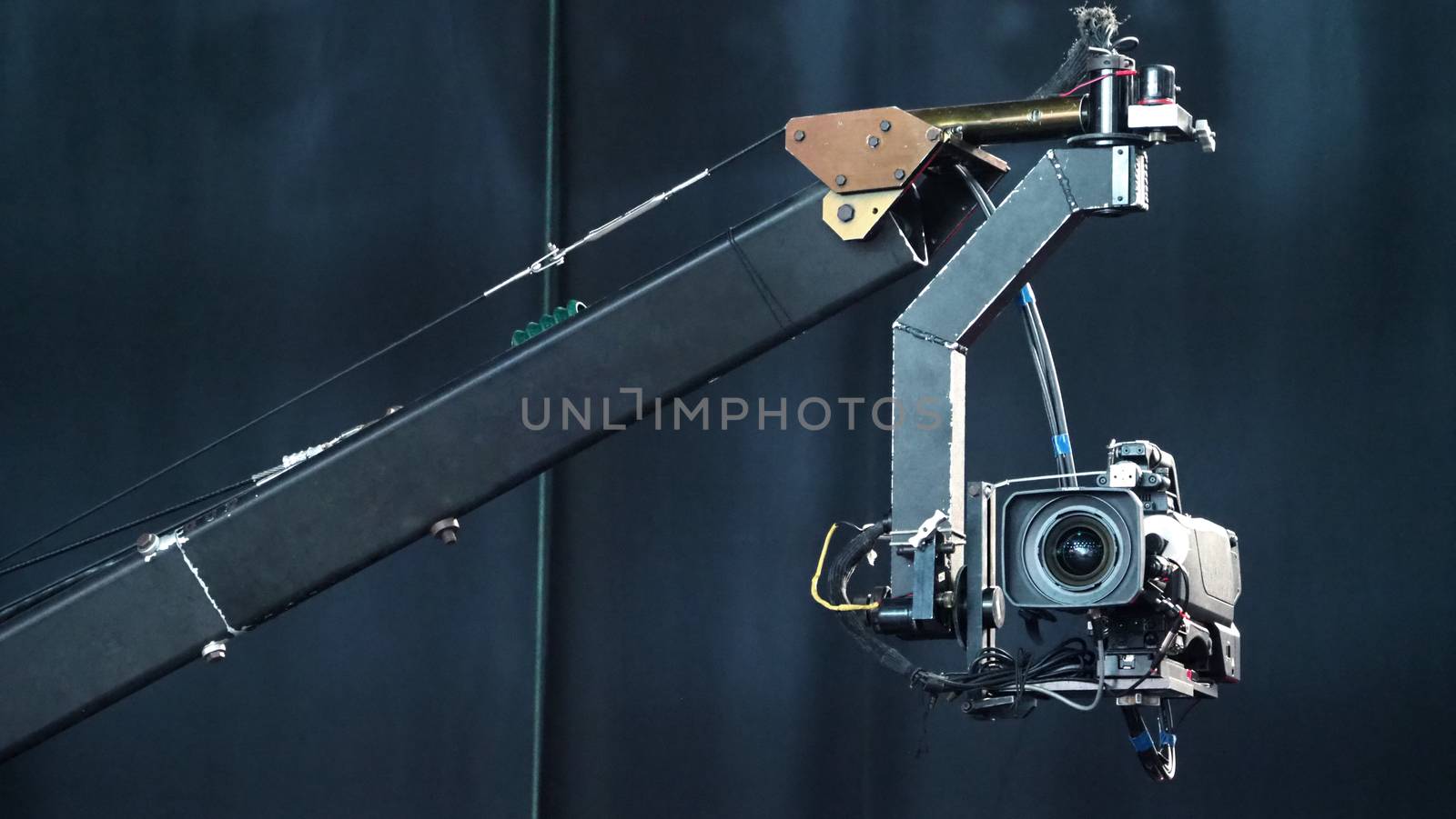 Blurry images of broadcast camera on the crane tripod for easy to shooting or recording and broadcasting content in studio production to on air tv or online internet live show.