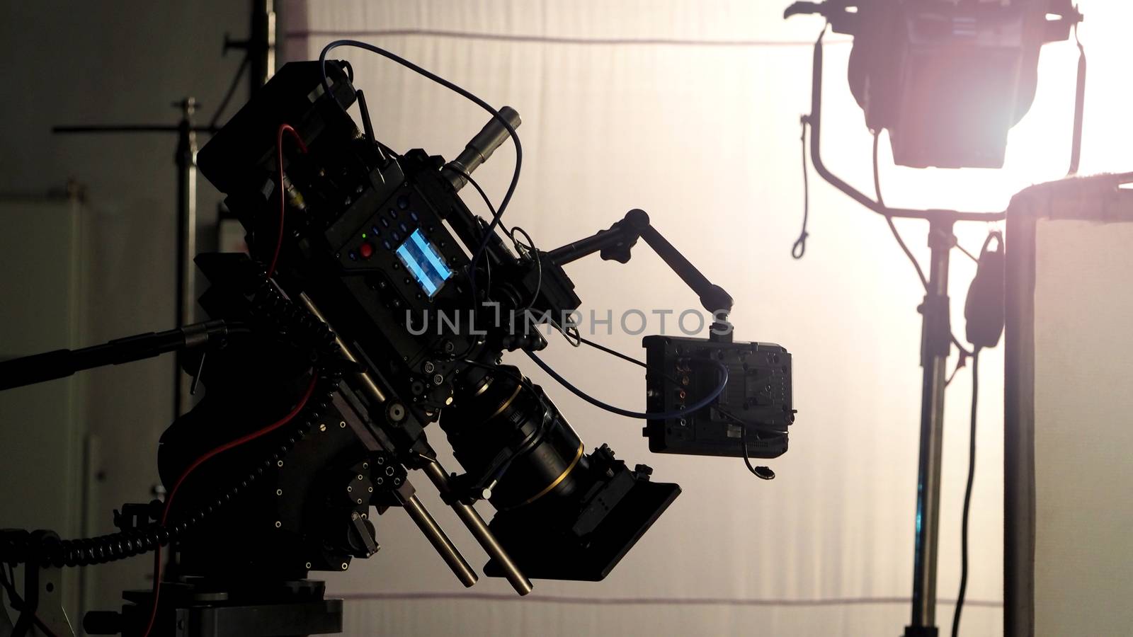 Video camera in film or movie production on tripod and professional gear which shooting in location or studio with crew team and beautiful prop or set and ready to online live broadcast or tv on air later 