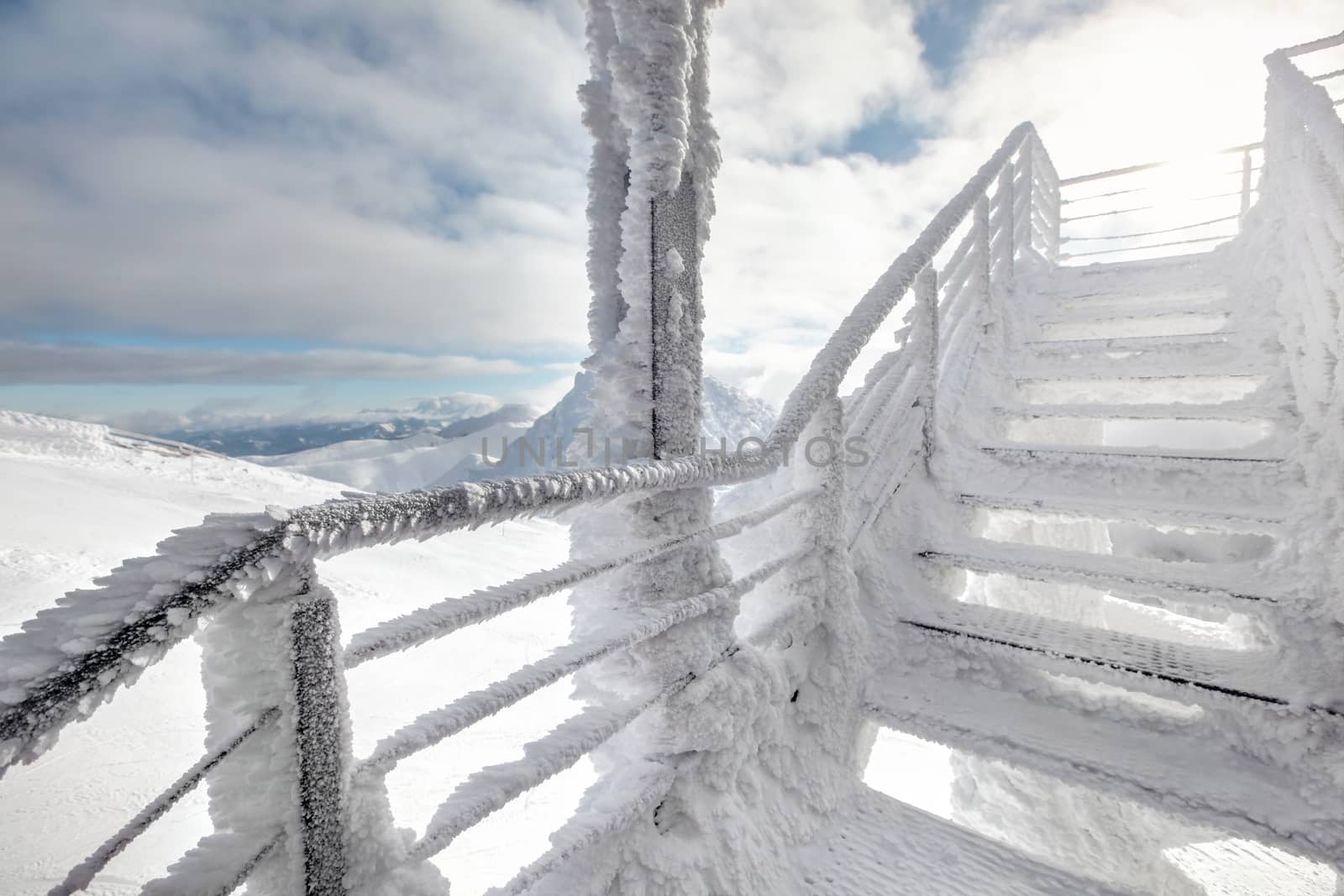 Snow and ice covered stairs, with strong sun backlight in backgr by Ivanko