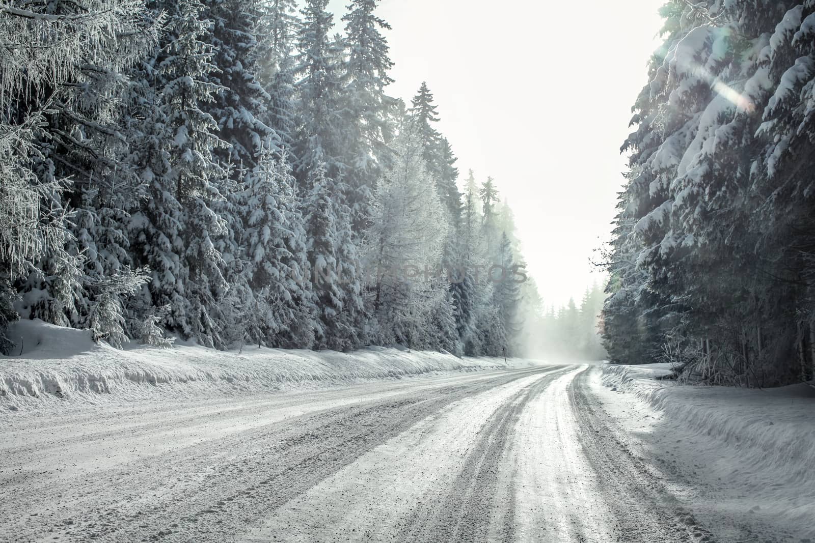 View from a car riding through snow covered winter road curve, l by Ivanko